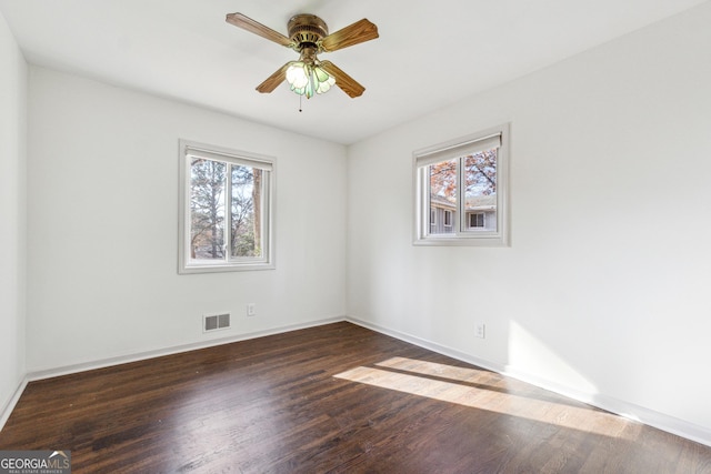 unfurnished room featuring ceiling fan, dark hardwood / wood-style flooring, and a healthy amount of sunlight