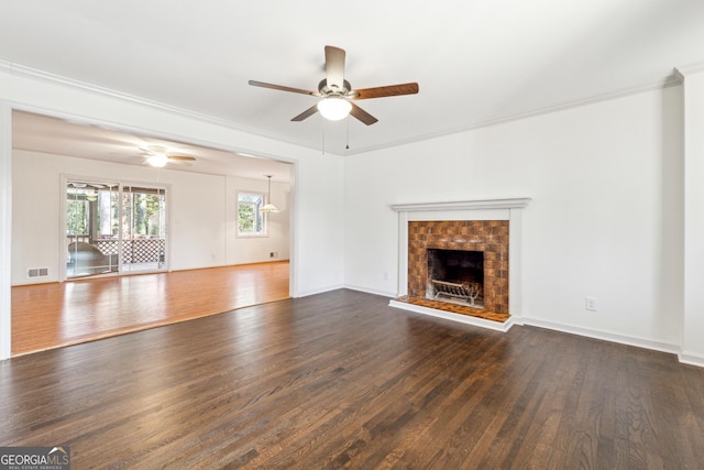 unfurnished living room with dark hardwood / wood-style flooring, crown molding, and a brick fireplace