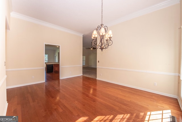 unfurnished room with ornamental molding, hardwood / wood-style floors, and an inviting chandelier