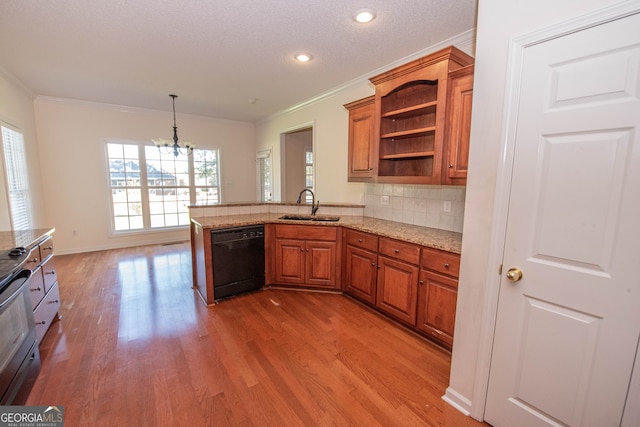 kitchen with light wood-type flooring, sink, kitchen peninsula, hanging light fixtures, and black dishwasher