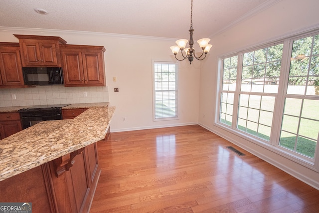 kitchen with light stone counters, black appliances, crown molding, and light hardwood / wood-style flooring