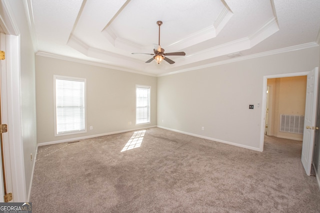 carpeted spare room with ceiling fan, a raised ceiling, and crown molding