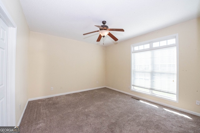 empty room featuring ceiling fan and carpet flooring