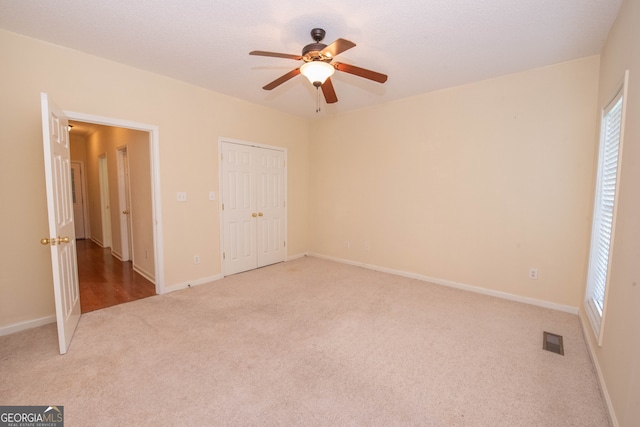 unfurnished bedroom featuring ceiling fan and light colored carpet