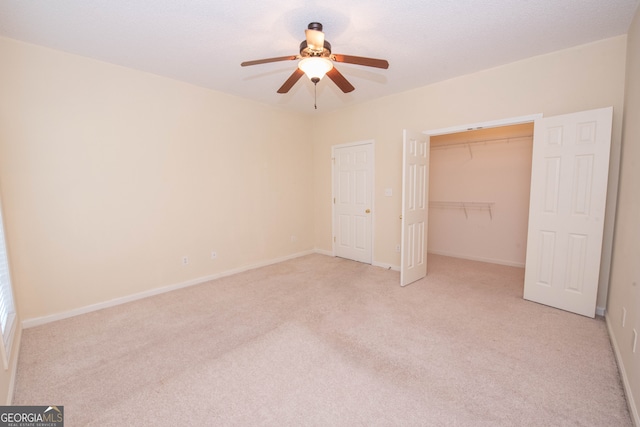 unfurnished bedroom featuring ceiling fan, light colored carpet, and a closet