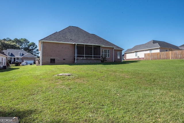 rear view of house with a sunroom and a yard