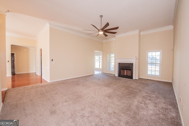 unfurnished living room featuring carpet floors, ornamental molding, and ceiling fan