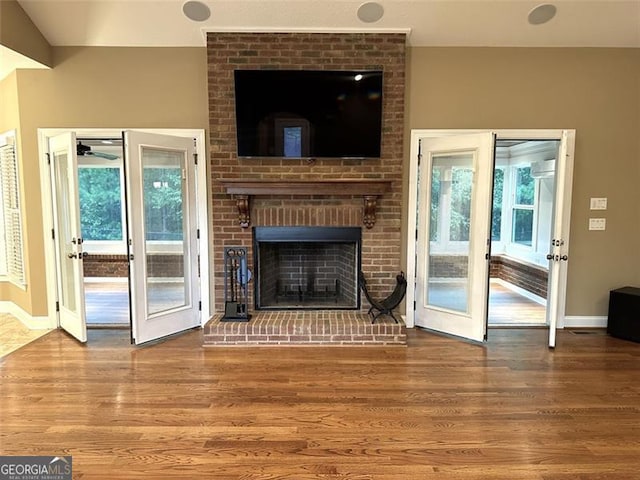 unfurnished living room with wood-type flooring, a fireplace, and plenty of natural light