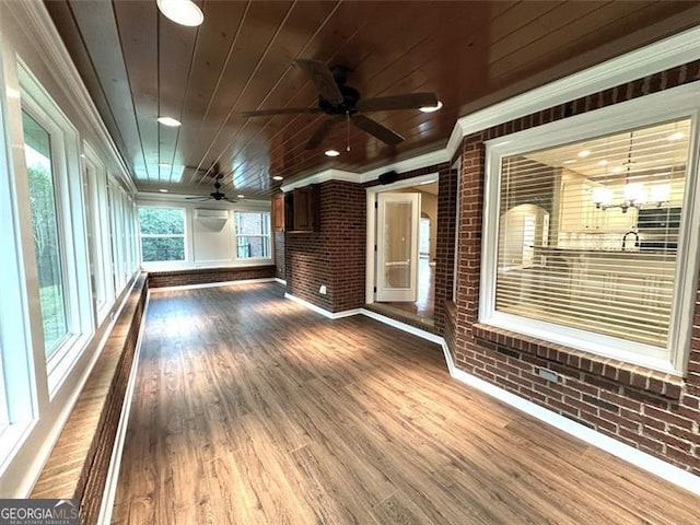 unfurnished sunroom featuring wood ceiling and ceiling fan