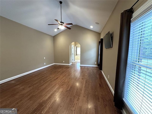 interior space with ceiling fan, dark wood-type flooring, plenty of natural light, and vaulted ceiling