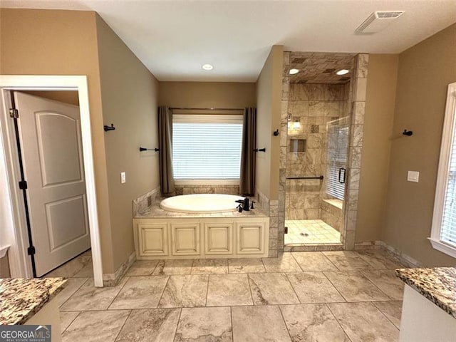 bathroom with vanity and shower with separate bathtub