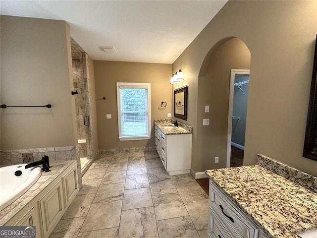 bathroom featuring independent shower and bath and vanity