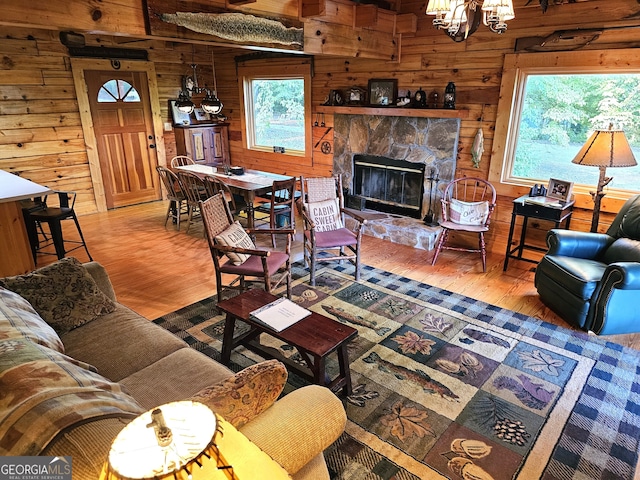 living room featuring wood walls, a chandelier, hardwood / wood-style flooring, and a fireplace