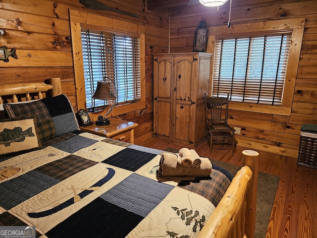 bedroom with wood-type flooring and wooden walls