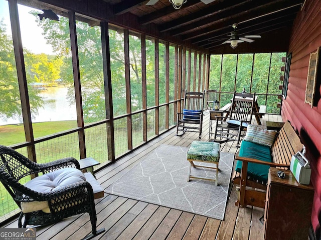 sunroom / solarium featuring beamed ceiling, a water view, ceiling fan, and a healthy amount of sunlight