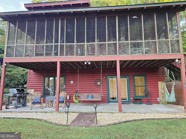 back of property with a patio area and a sunroom