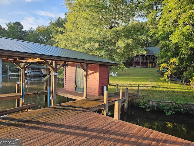 view of dock with a water view and a lawn