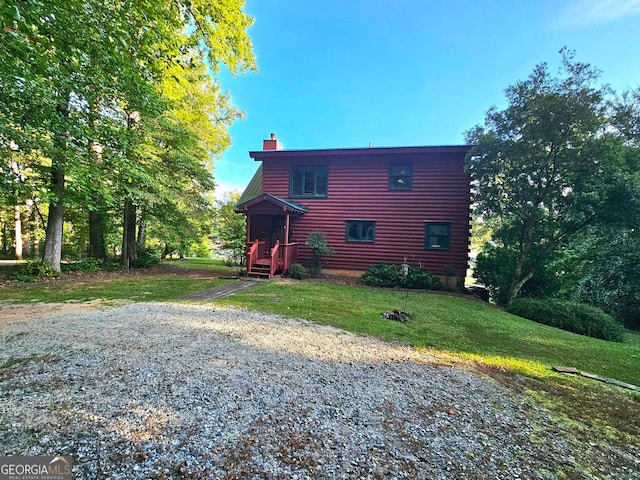 rear view of house featuring a yard