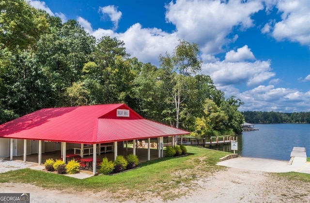 exterior space with a dock, a water view, and a yard