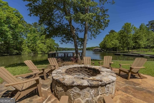 view of patio with a water view and a fire pit