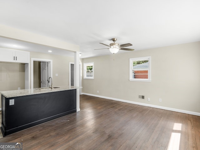 interior space featuring dark hardwood / wood-style floors, sink, white cabinetry, light stone countertops, and ceiling fan