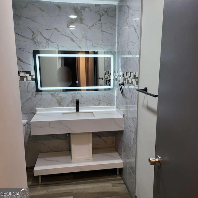 bathroom featuring wood-type flooring and tile walls