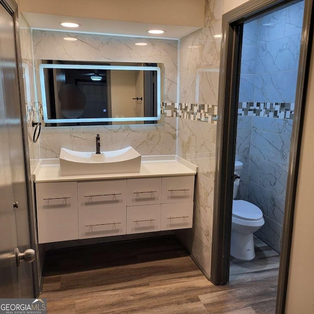 bathroom with vanity, tile walls, hardwood / wood-style floors, and toilet