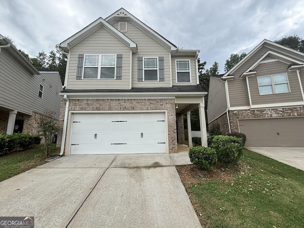 craftsman house featuring brick siding, a garage, and driveway