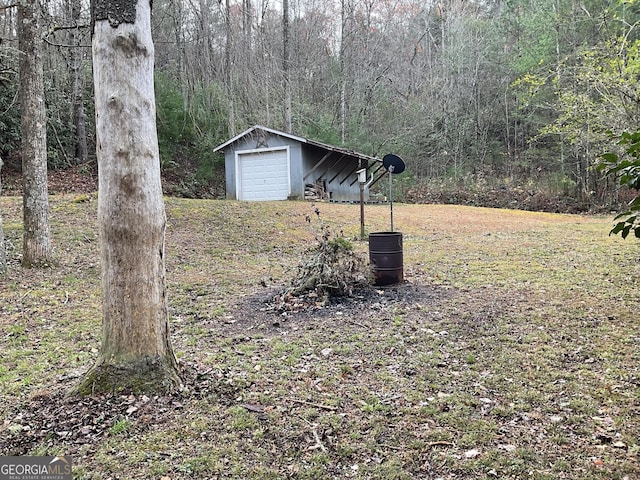 view of yard featuring a garage and an outdoor structure