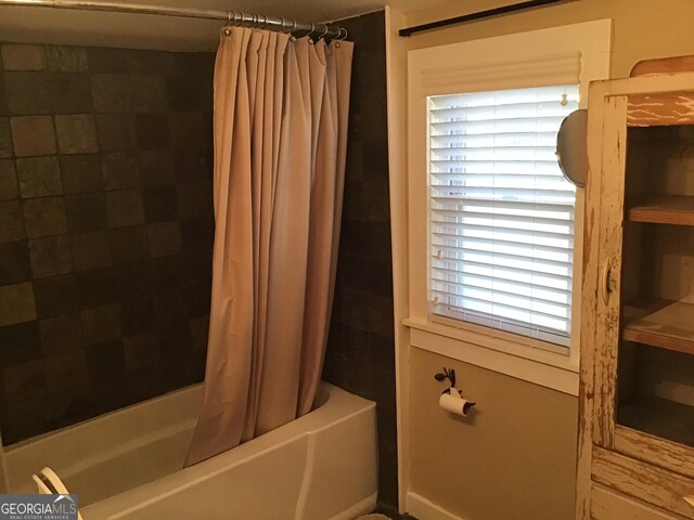 bathroom featuring shower / tub combo with curtain and a wealth of natural light