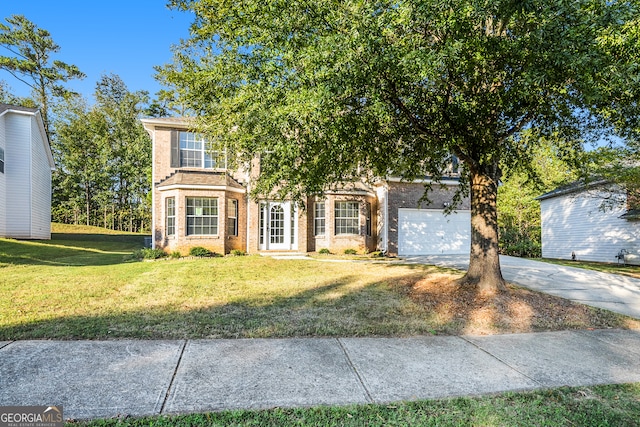 view of property hidden behind natural elements featuring a garage and a front yard