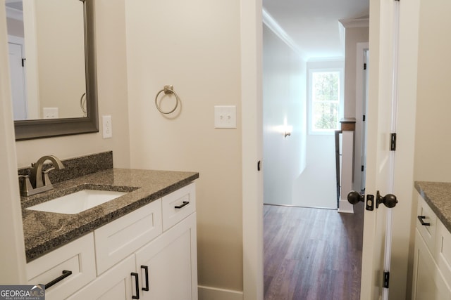 bathroom with hardwood / wood-style floors, vanity, and ornamental molding