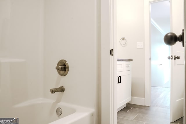 bathroom featuring vanity, hardwood / wood-style flooring, and shower / washtub combination