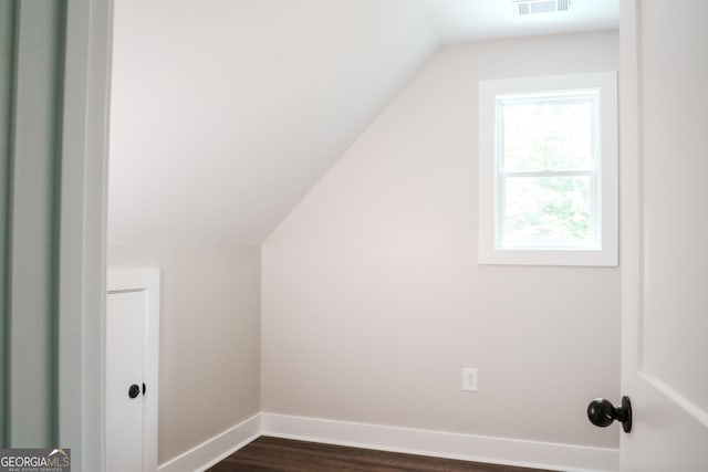 bonus room featuring dark wood-type flooring and vaulted ceiling