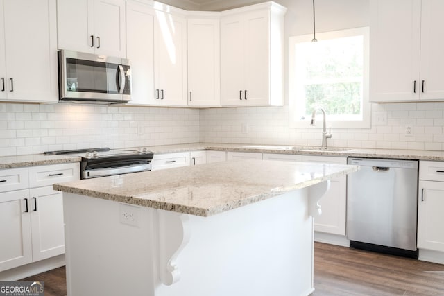 kitchen with hardwood / wood-style flooring, white cabinetry, sink, and appliances with stainless steel finishes