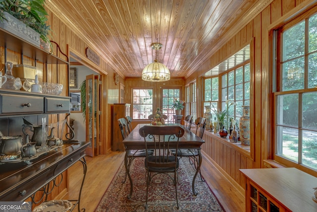 dining room featuring an inviting chandelier, hardwood / wood-style flooring, wooden ceiling, and a healthy amount of sunlight