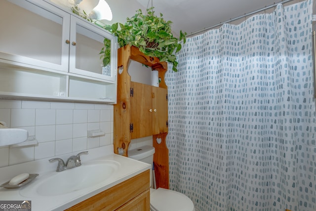 bathroom with decorative backsplash, vanity, and toilet