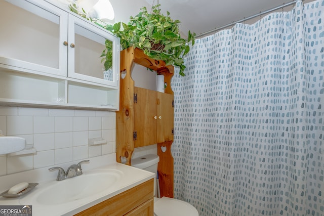 bathroom featuring tasteful backsplash, vanity, and toilet