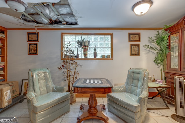 sitting room featuring crown molding and light tile patterned floors