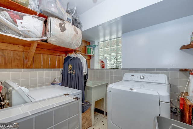 laundry area with tile walls and washer / dryer