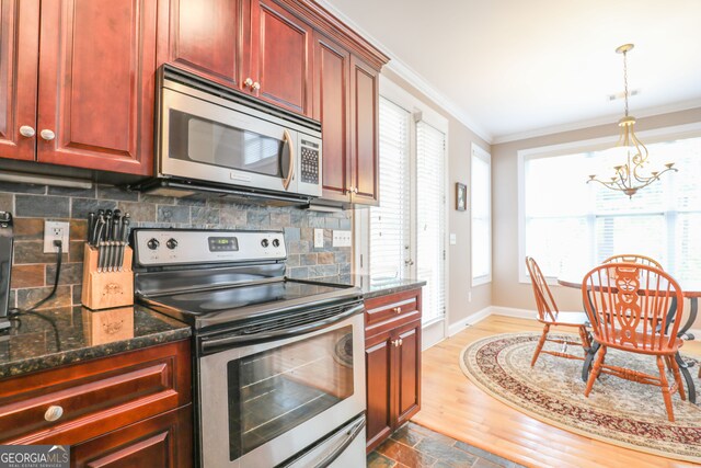 kitchen with dark stone countertops, stainless steel appliances, dark wood-type flooring, and backsplash