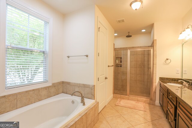 bathroom with vanity, independent shower and bath, plenty of natural light, and tile patterned flooring