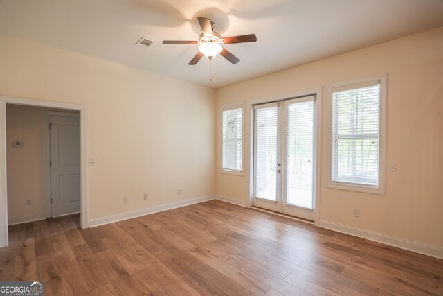 spare room with french doors, hardwood / wood-style floors, and ceiling fan