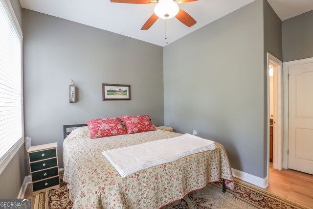 bedroom featuring multiple windows, hardwood / wood-style flooring, and ceiling fan