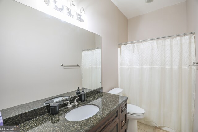 bathroom with toilet, vanity, and tile patterned floors