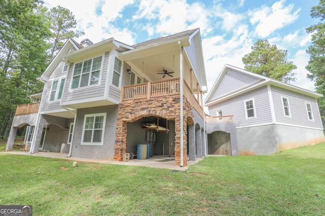 rear view of house with a patio area, a balcony, a lawn, and ceiling fan