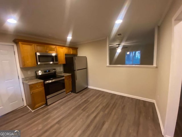 kitchen featuring ornamental molding, stainless steel appliances, ceiling fan, and dark hardwood / wood-style floors