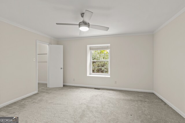 unfurnished room featuring light carpet, ceiling fan, and crown molding