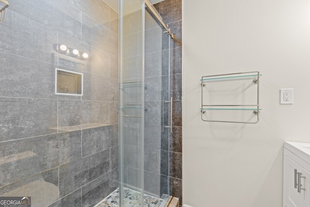 bathroom with vanity and a shower with shower door