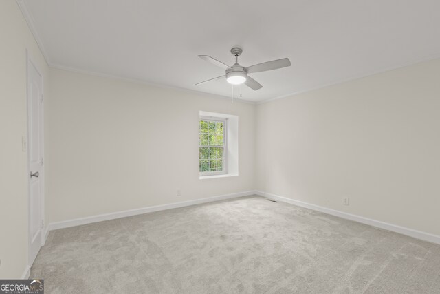 carpeted spare room featuring ornamental molding and ceiling fan